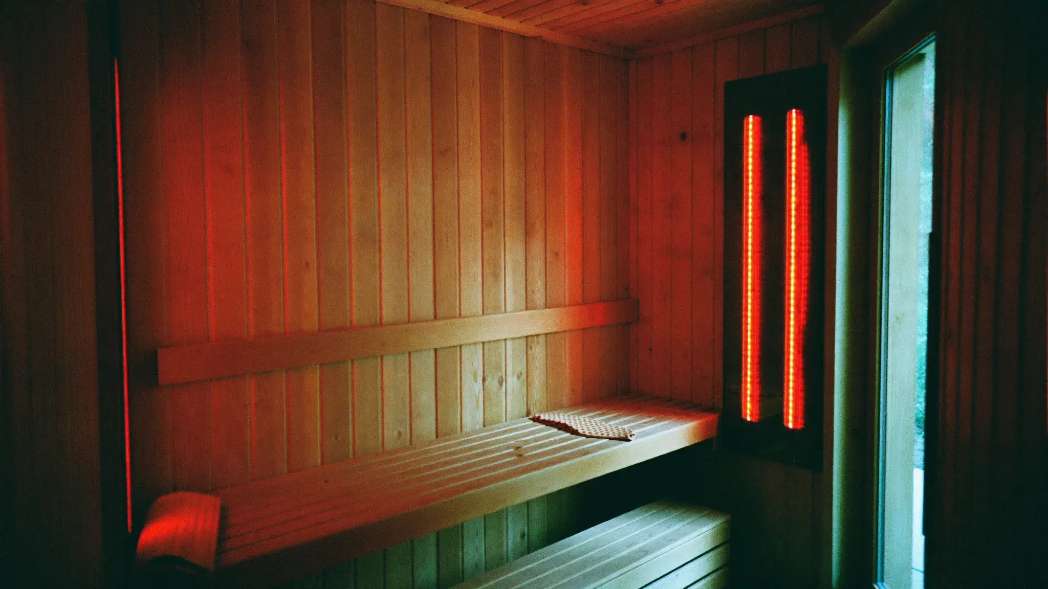 The infrared sauna room, lit by red heat lamps
