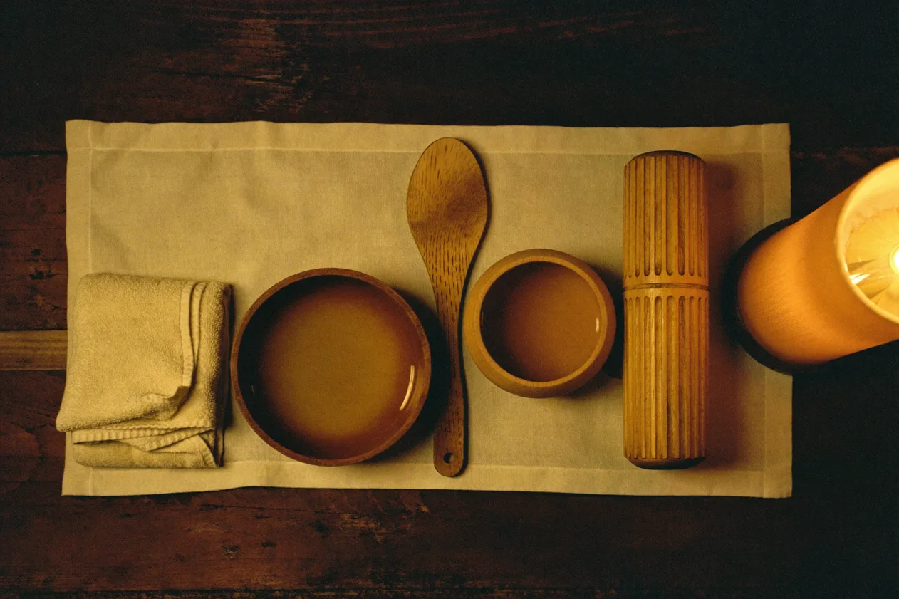 Treatment tools laid out on linen: wooden bowls, a spatula and a roller