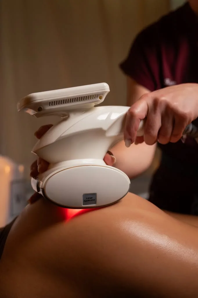 Body sculpting device with a red light working over a client's hip